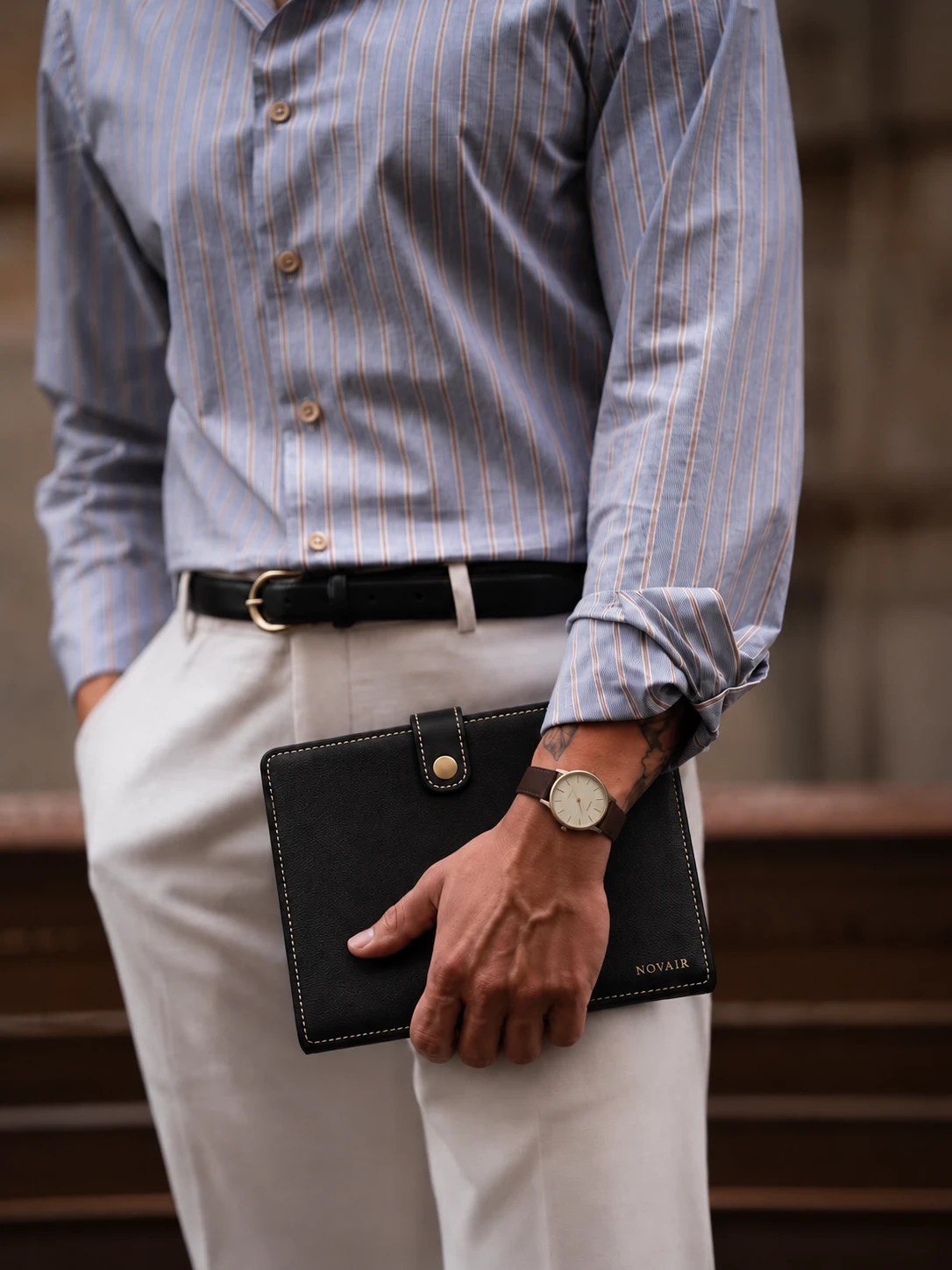 NOVAIR folio carried at the hip by a man in a striped shirt